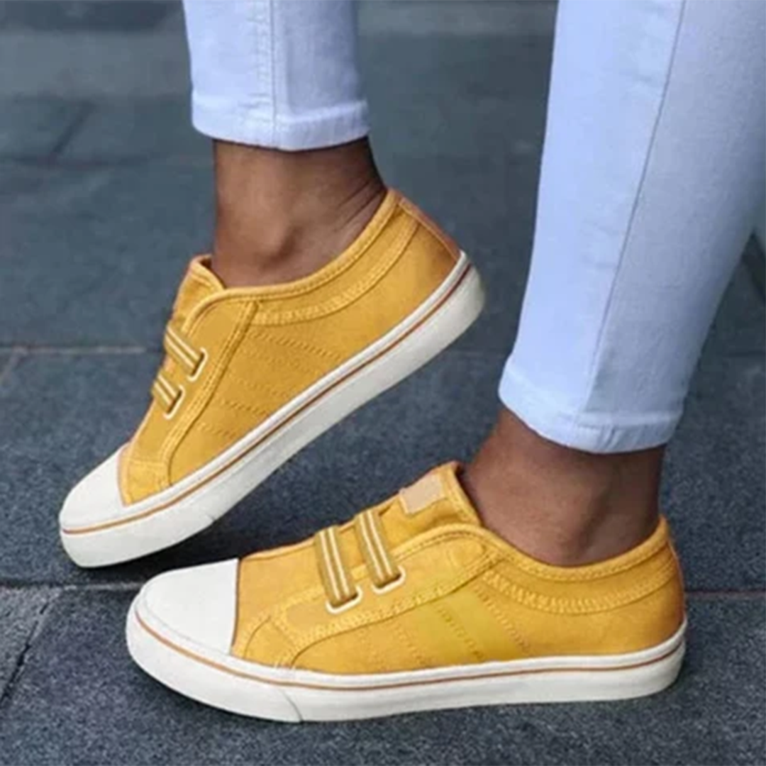 Gele canvas sneakers met witte zolen en klittenbandsluiting, gedragen door persoon in witte broek. Stijlvolle casual schoenen voor dagelijks gebruik.