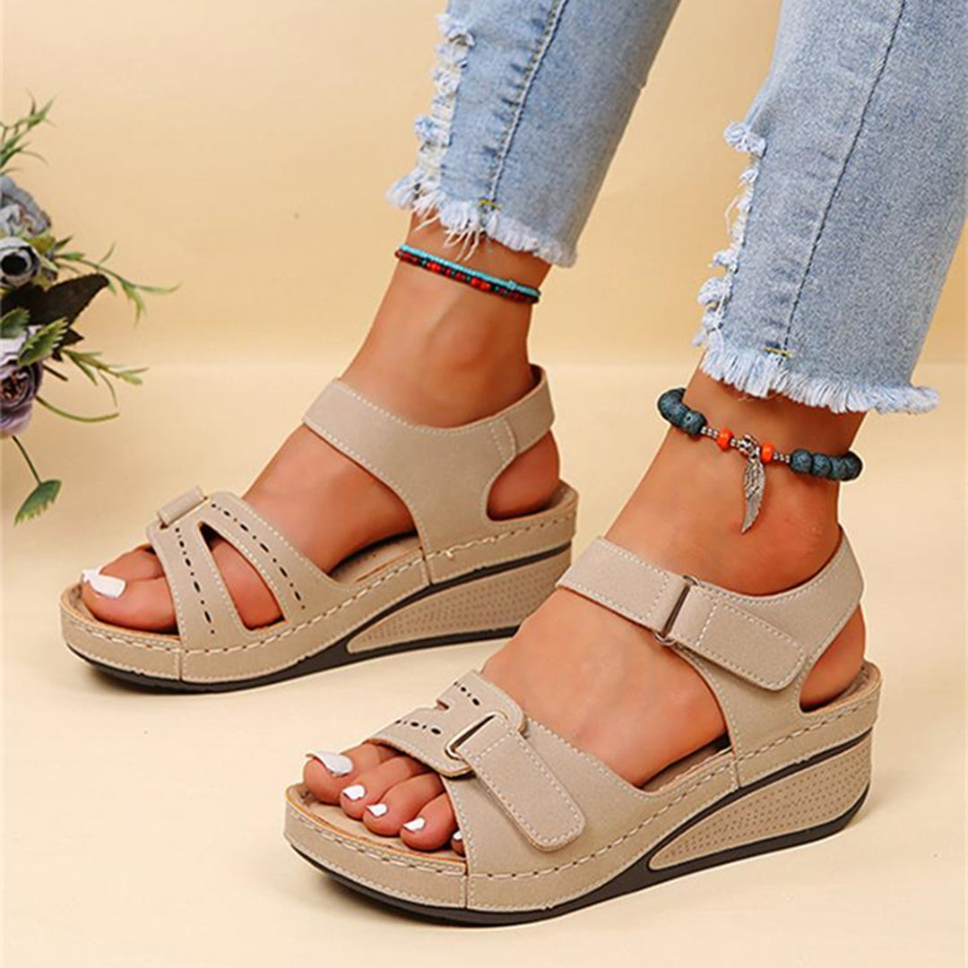 Beige sandalen met sleehak, verstelbare bandjes en comfortabele zool, gedragen met gerafelde jeans. Perfect voor zomerse casual outfits.