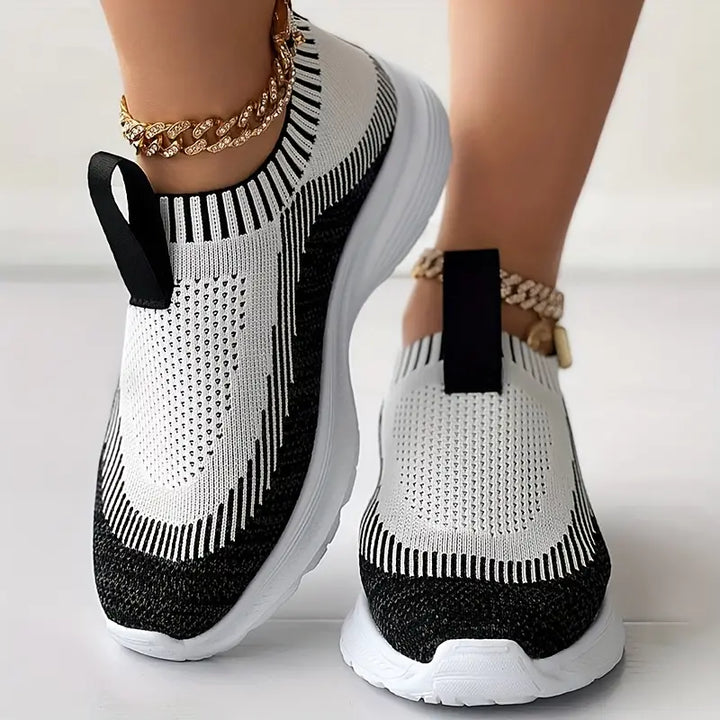 Zwart-witte damessneakers met gouden enkelbandjes, ademend mesh ontwerp, slip-on stijl, comfortabele sportieve schoenen voor dagelijks gebruik.